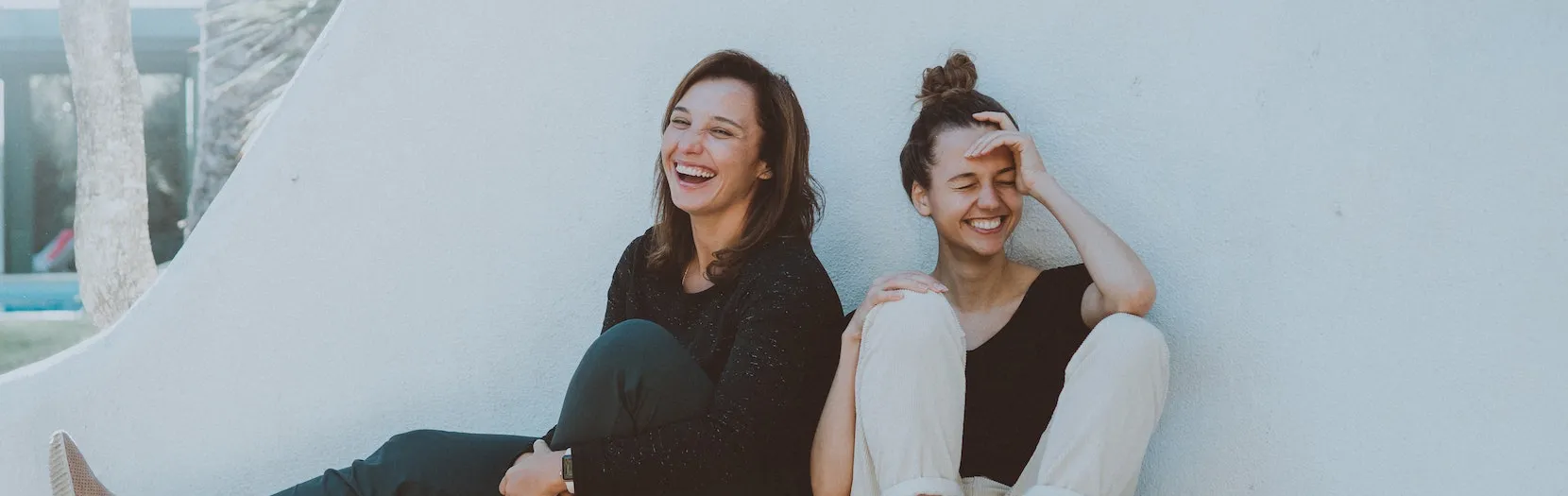 Two girls sitting outside and laughing together. Our category of Comedy found at Ads4Dads.com