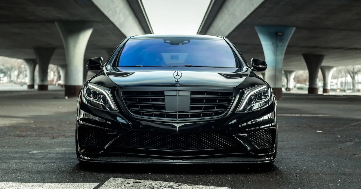 A shiny black Mercedes Benz parked underneath two overpasses. Learn why ceramic coatings are awesome and better than wax.