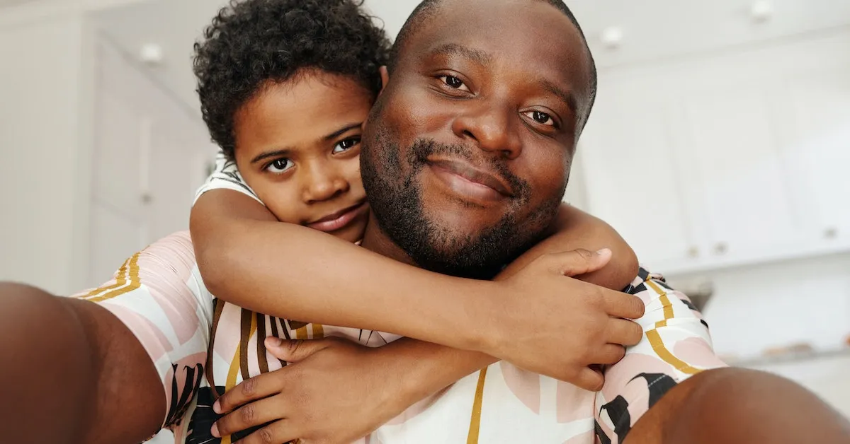 A young boy embracing his father. They both look very happy. Learn how to be a great father in this article.