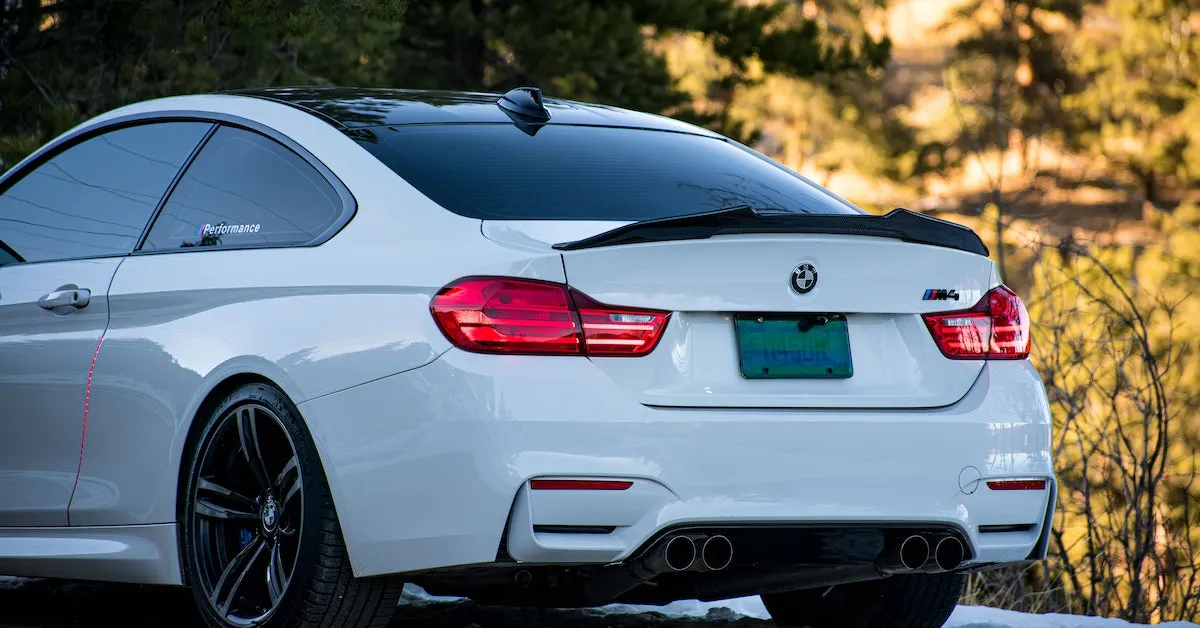 A white BMW M4 with black tinted windows. The car looks very shiny and very sporty. Learn why your back window bubbles and how to avoid it.