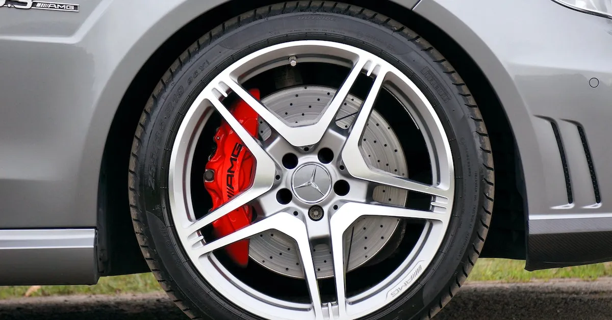 A close up picture of a silver, Mercedes Benz AMG wheel with a red brake caliper. Are you ready to buy new tires? Learn some insider tips in this article.