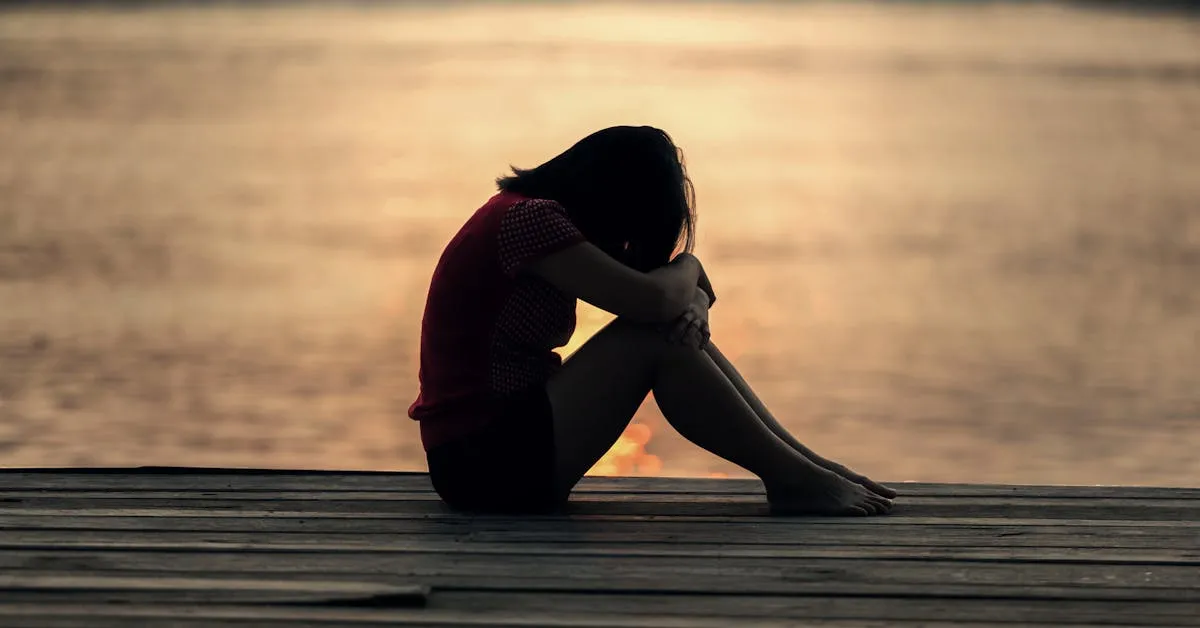 A sad women grieving by the ocean. Learn how to deal with loss and pain.