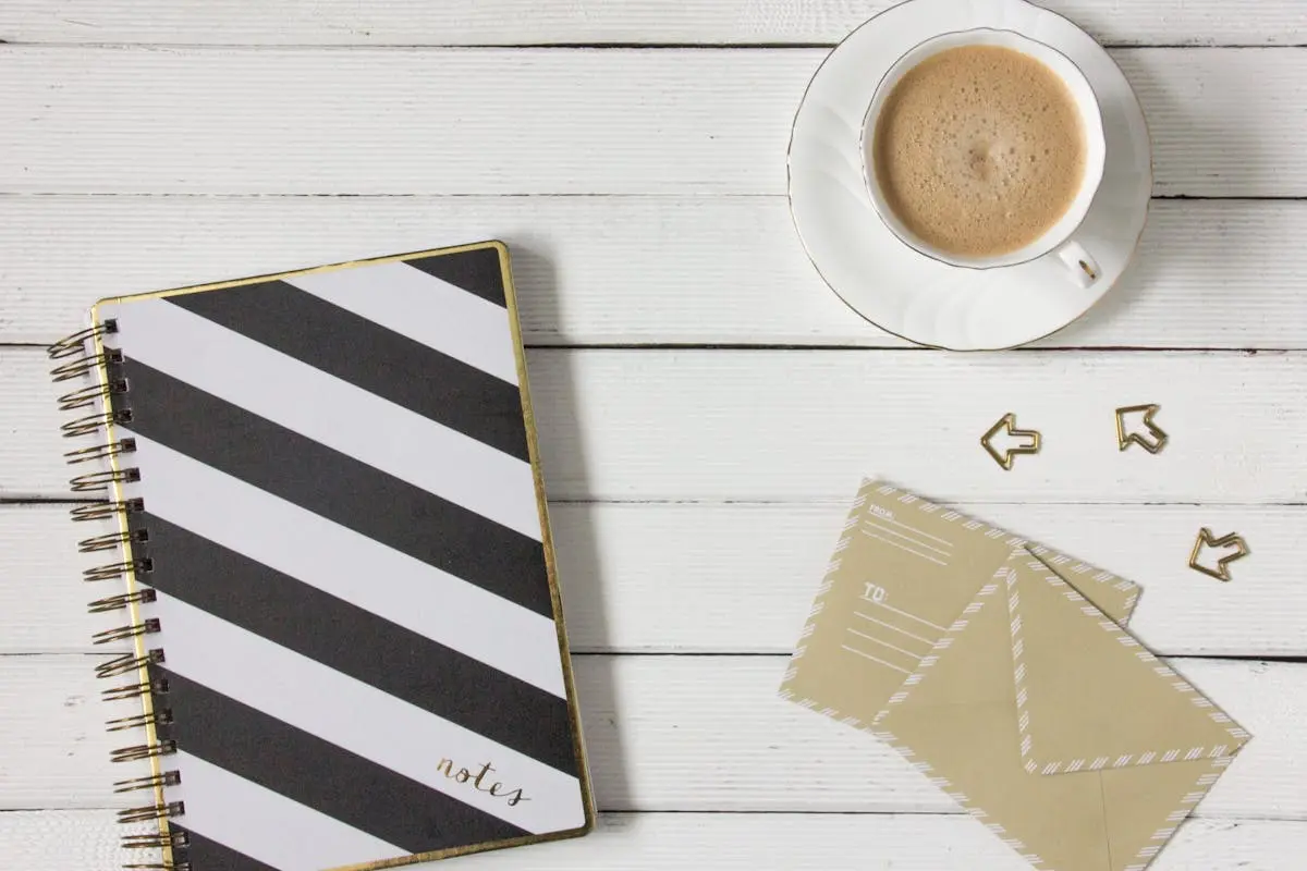 There is a black and white stripped notebook on the left with a coffee cup and two letters waiting to be sent. It's a perfect time to consider our lives and position ourselves in-line with a bigger purpose in life. Learn more in this latest article about your mission.