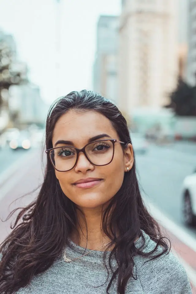 A pretty woman with glasses, smiling, and looking straight into the camera. She is the kind of woman who knows what she wants and works hard to get it.