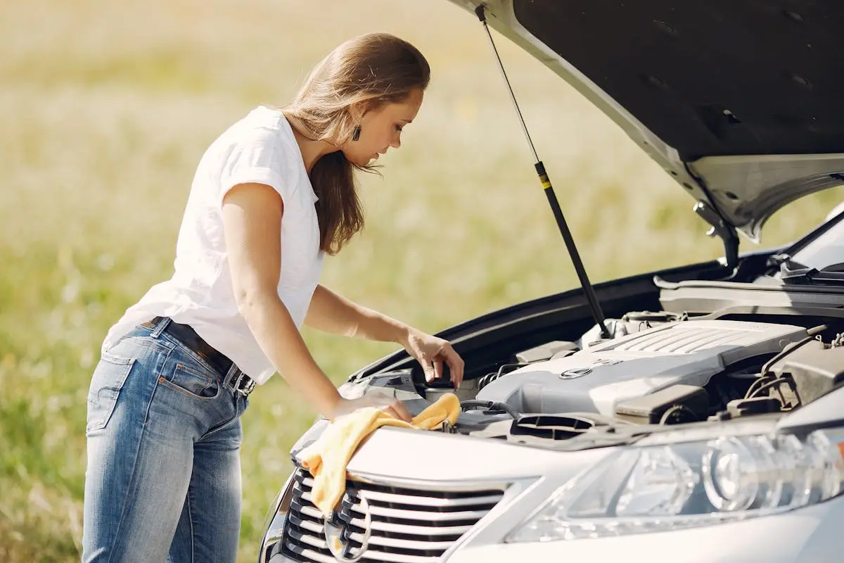 A woman looking under the hood of her car trying to figure out what is wrong. Are you experiencing issues with your air conditioning? Take a look at our latest article, you may find it very helpful.