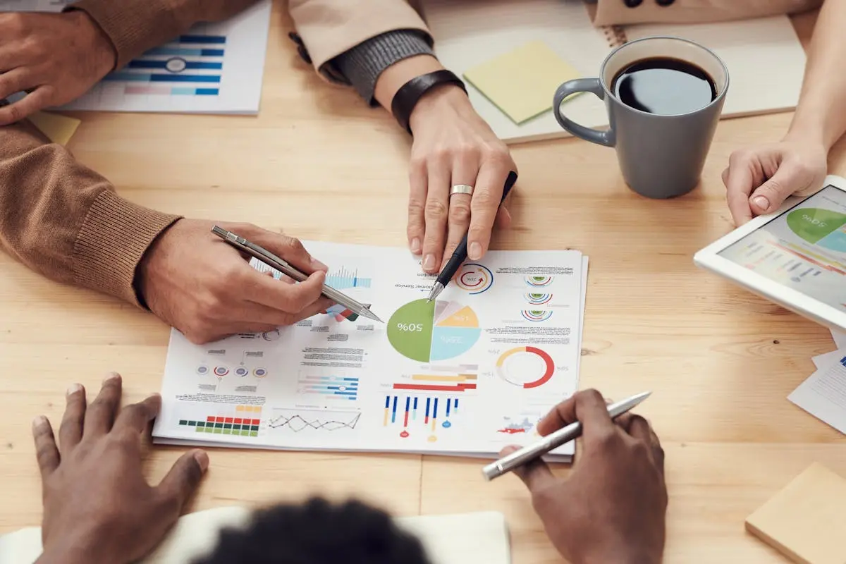 A spreadsheet with colored charts on a table with many people collaborating around them to make the best decision. Having a sucessful and meaningful life takes planning and having hard work. Learn more in our recent article for insight to planning a meaningful life.