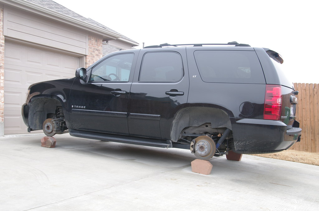 A black Chevy Tahoe with missing wheels. They wheels were stolen while it was parked at their house.