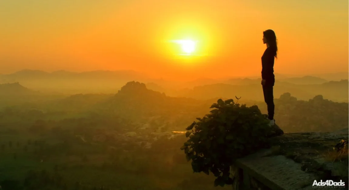 A woman looking out into the distance during a sunset. She is amazed at the beauty of life and thinks about God. If you are thinking about God today, take a look at our recent article Remembering God in Everyday Life.